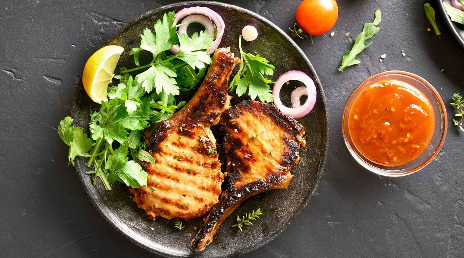 Cooked meat, salad, coriander and lemon on a plate